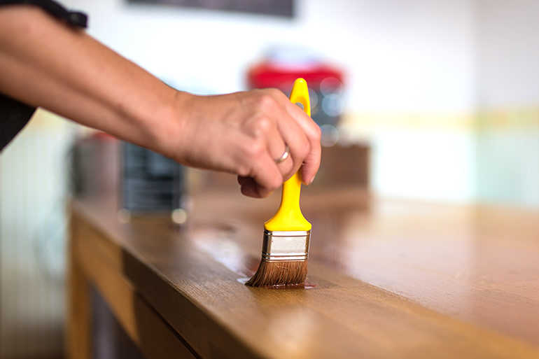 Tisch aus Massivholz mit einem Pinsel einölen